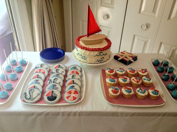 Nautical baby shower table decor with sail boat cake and cookies