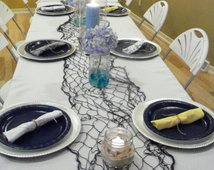 Nautical baby shower table setting with net and mason jars