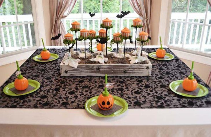 Orange kids Halloween table with pumpkins and cupcakes replicas