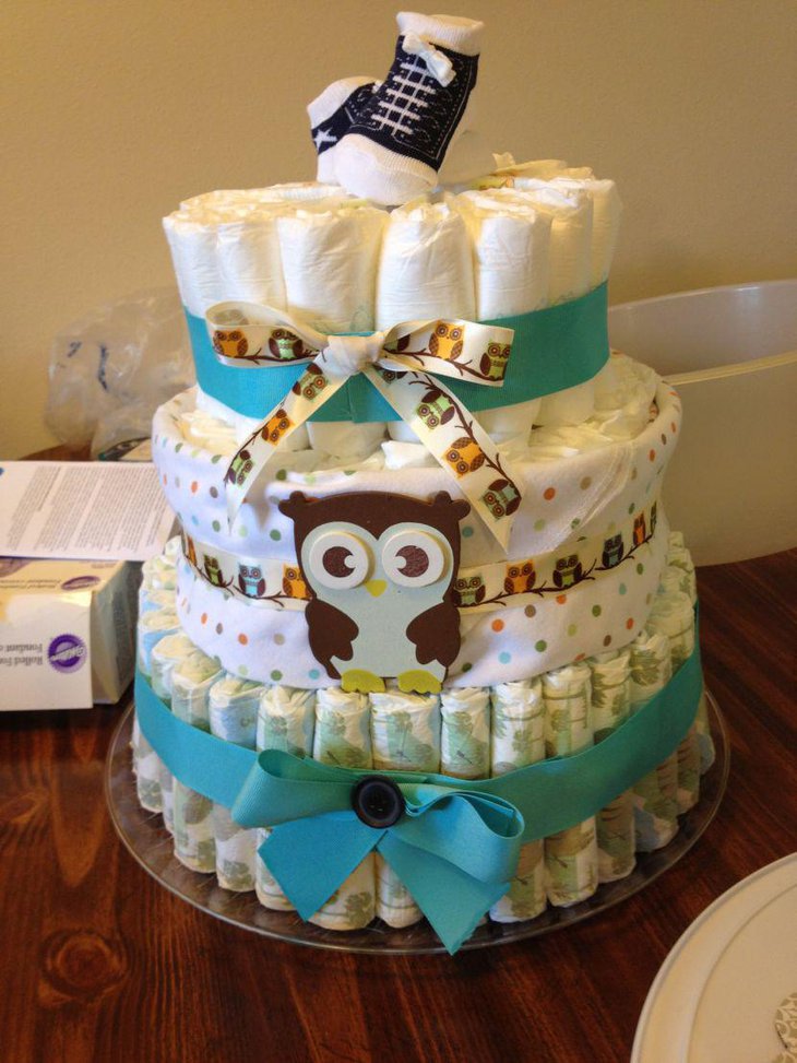 Owl diaper cake centerpiece wrapped with blue ribbon