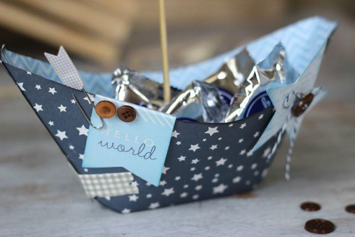 Paper sailboat centerpiece for nautical themed baby shower table