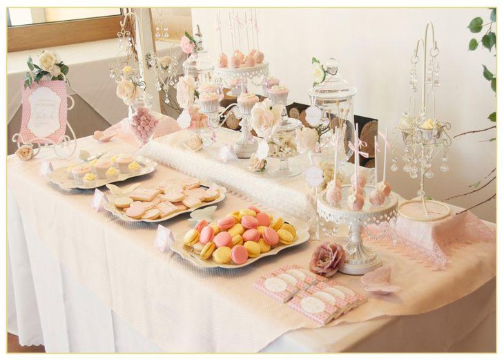 Pastel themed European dessert table laid out with cupcakes and cake pops
