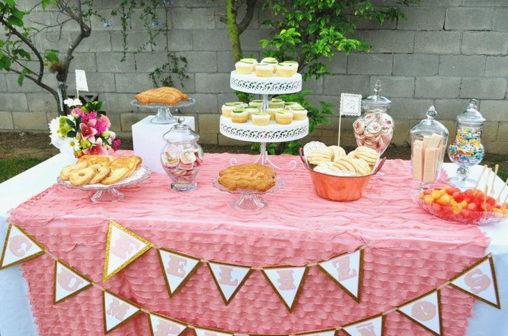 Pink and white floral decor seen on this 80th birthday dessert table