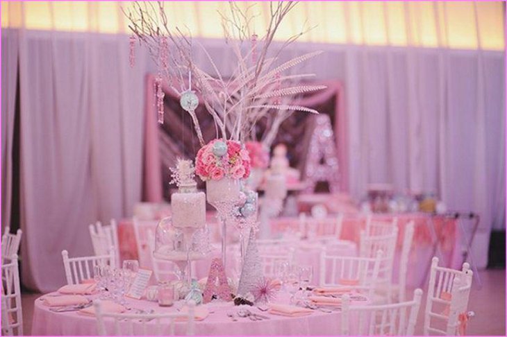 Pink flowers and twigs decor on winter wonderland table