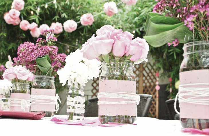 Pink themed flower arangement in mason jars for wedding table