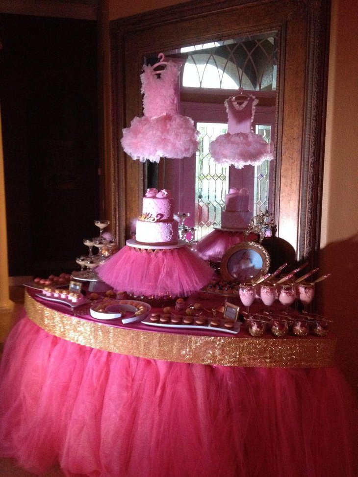 Pretty baby shower dessert table decor with pink cake and frilly cakestand