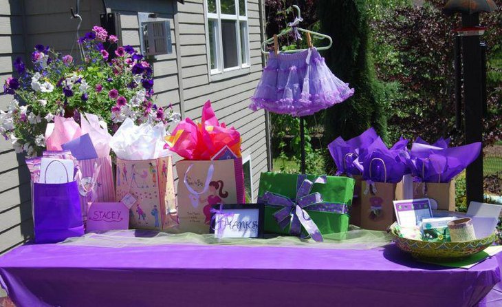 Purple baby girls shower decorations on table