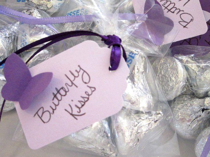 Purple butterfly decorations on baby shower sweets table