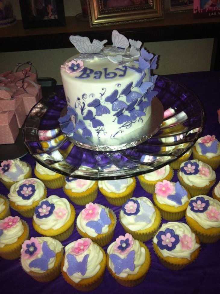 Purple butterfly themed cake and cupcake decorations on baby shower table