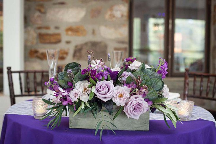 Purple floral arrangement on wedding party table