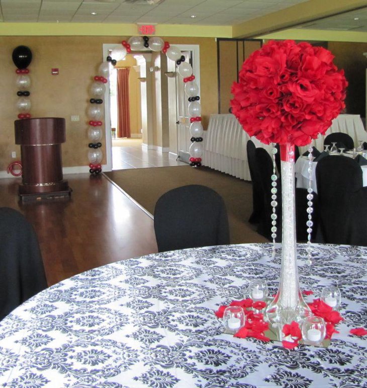 Red floral centerpiece displayed on an 80th birthday table