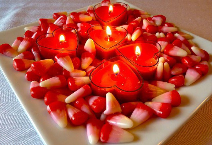 Red heart candles with candy cane decor on Valentines table