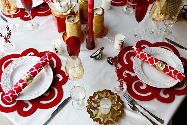 Red mats offer a contrasting effect with white candles and dinner plates