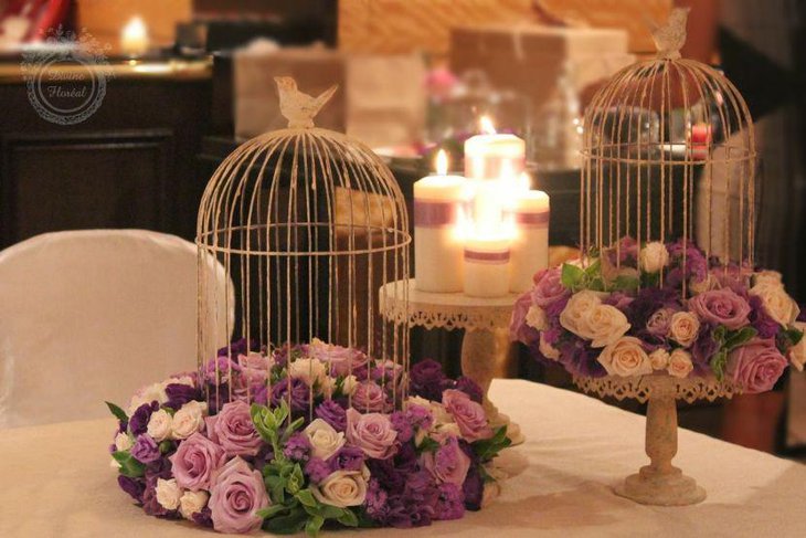 Romantic wedding tablescape with birdcage on purple floral wreath