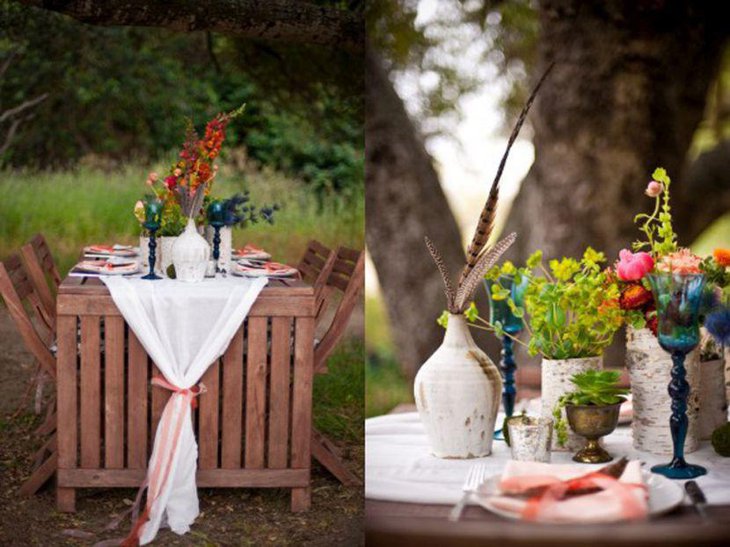 Rustic colourful outdoor party table setting with candlestands and flower vases