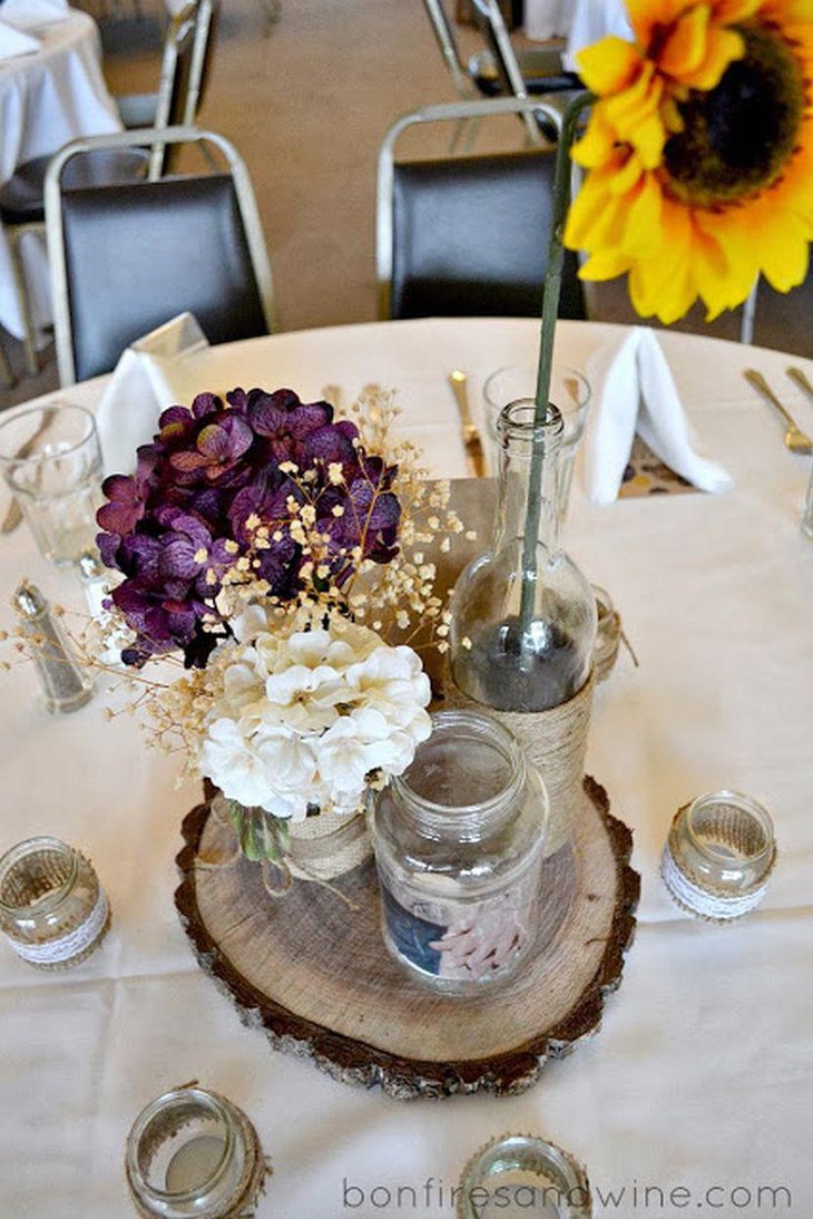 Rustic purple wedding table decor with flowers wooden slab and jars