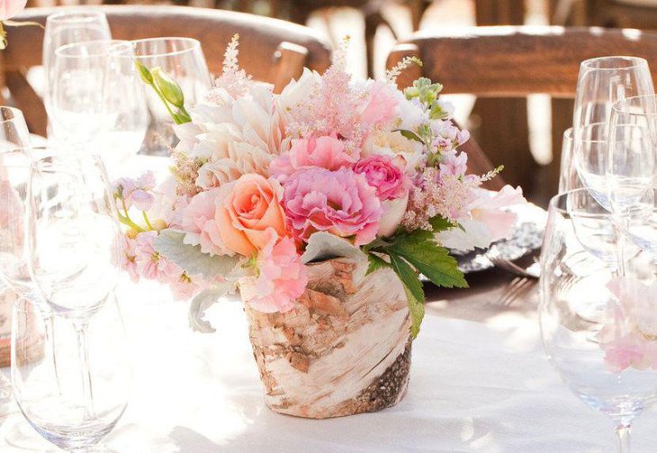Rustic vase with flowers centerpiece on spring wedding table