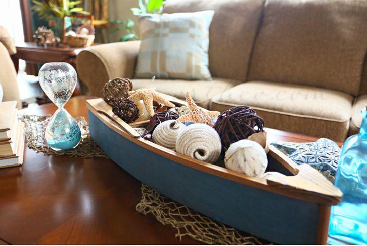 Sea themed coffee table decor with a boat and hourglass