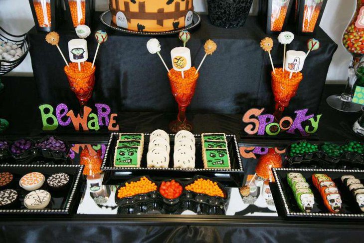Spooky Halloween party table for kids with ghost shaped candies and treats