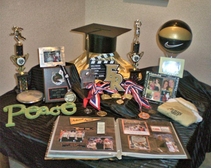 Sports trophy centerpieces on guys graduation display table