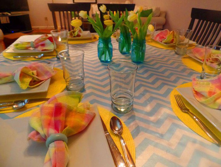 Springtime dinner table with blue and white table linen and yellow napkins