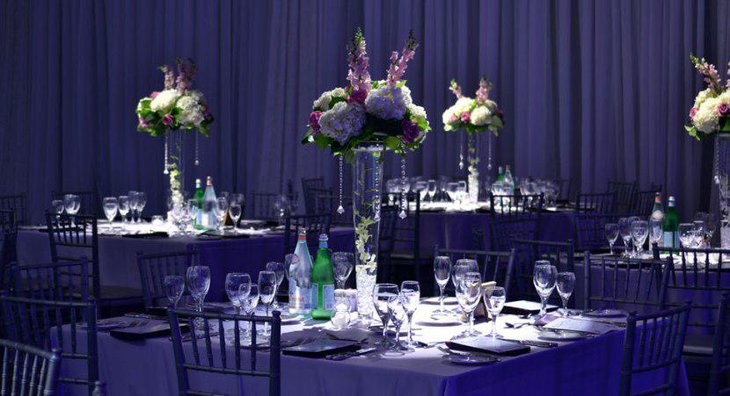 Square Wedding Table Ideas with Purple Satin Linen and tall Centerpiece Glass Vase