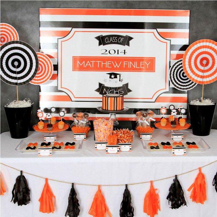 Stunning orange and black pinwheel centerpieces on graduation party table