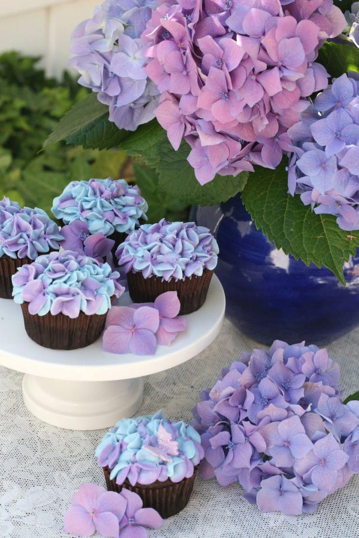 Stunning party table decor with purple hydrangea cupcakes and flowers