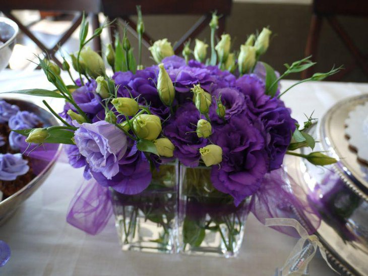 Stunning purple accented floral vase decoration on party table