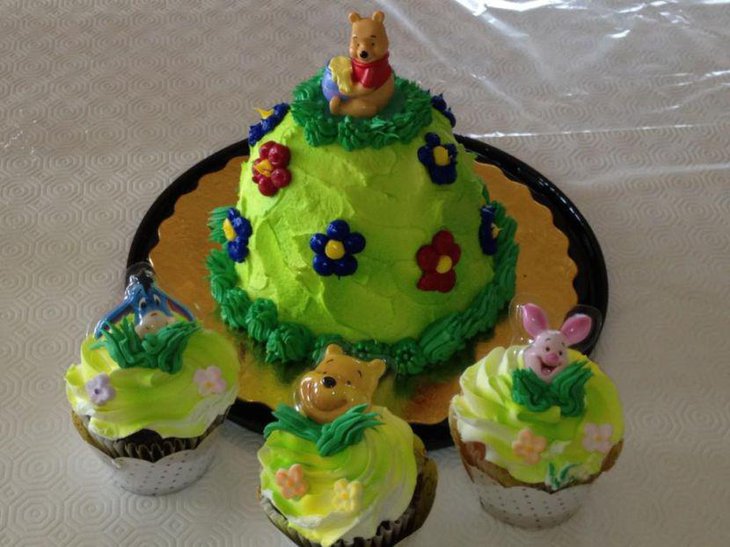Stunning Winnie The Pooh baby shower cake and cupcakes in green and floral accents