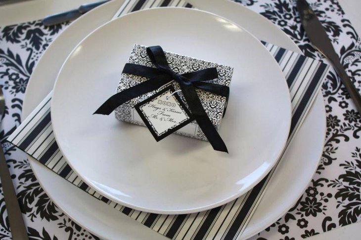 Stylish wedding table setting with black and white gift wrap mats and plates