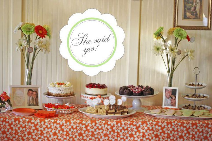 Sweet engagement party dessert table decor with fresh floral arrangements and assorted sweets