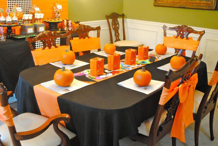 Unique orange and black themed Halloween table with pumpkin decorations