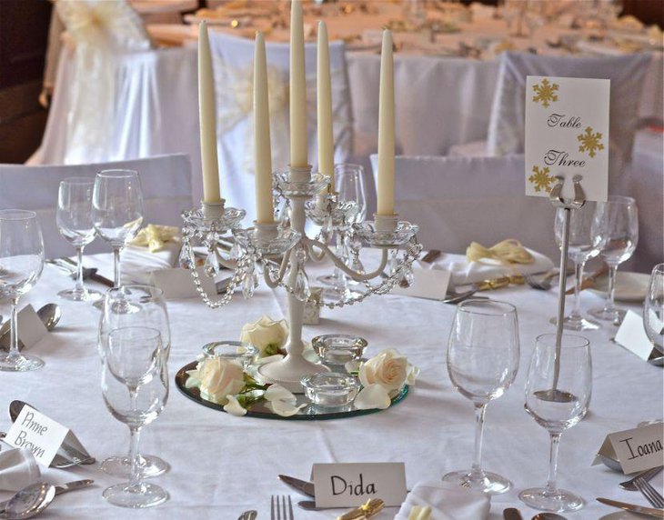 Wedding reception table decorations with white candles on crystal candle holder