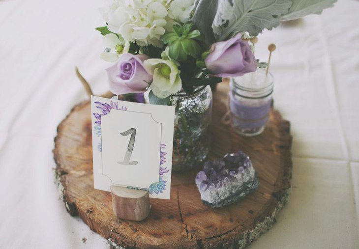 Wedding table decor with custom wedding table number and flowers with hints of purple