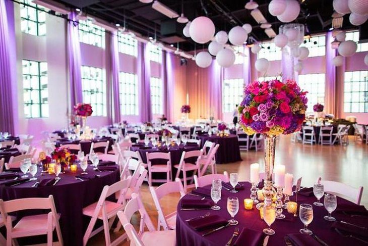 Wedding table decor with dark purple table cloth and flowers