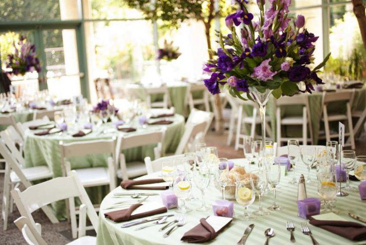 Wedding table decor with purple and green floral centerpiece