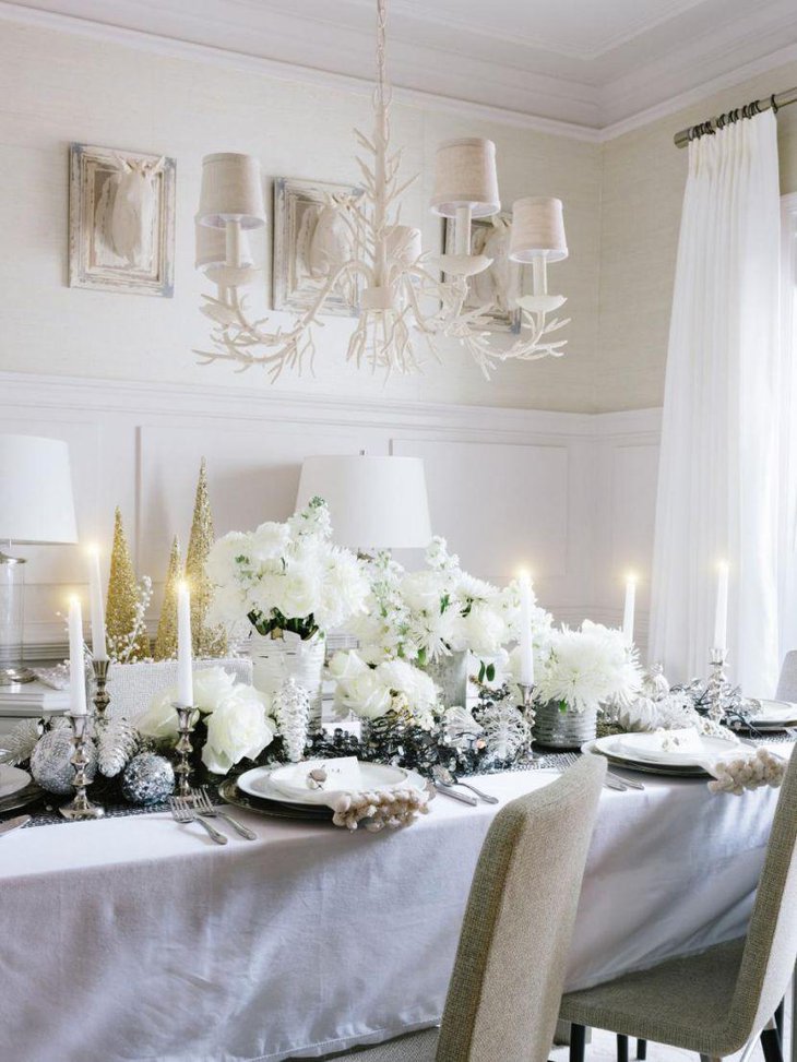 White Christmas tablescape with flowers and lit up candles