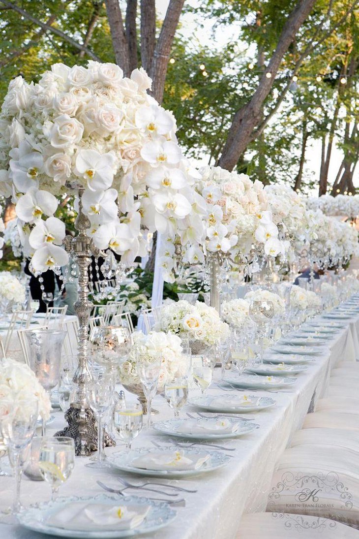 Winter wedding table decor with silver vases and white flower arrangements