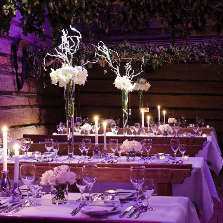Winter wedding table setting with tall glass floral centerpiece