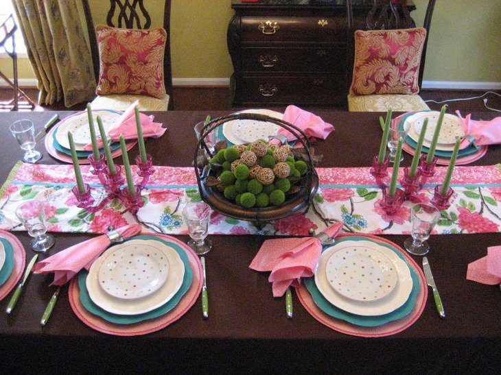 Wooden table setup with candles and green moss decor for spring dinner