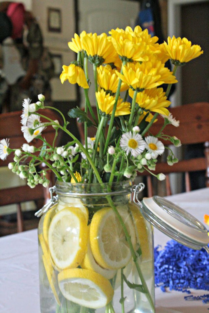 Yellow flowers decorated in grey jar filled with lemon slices for a gorgeous look