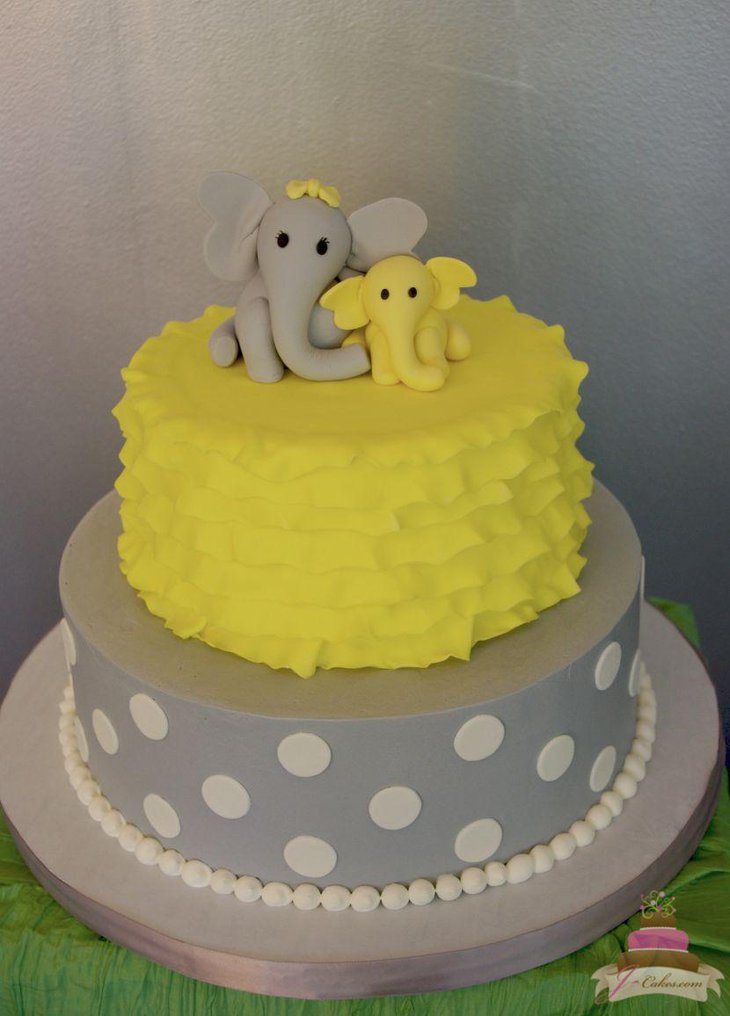 Yummy grey and yellow baby shower cake with elephants at top
