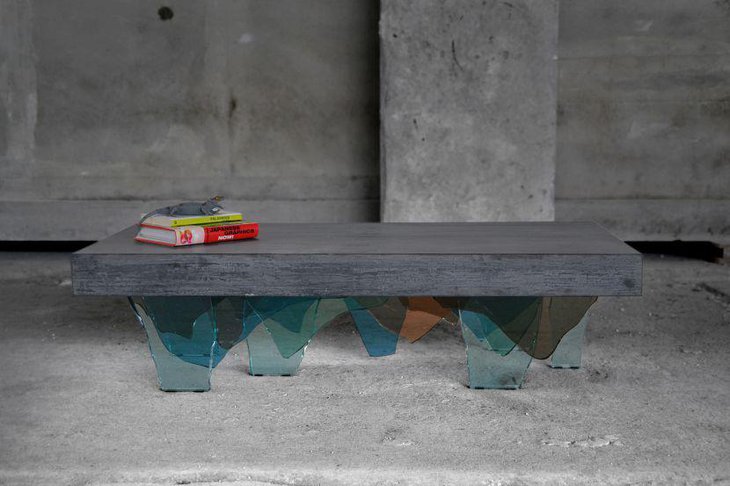 A concrete coffee table with a base made of colourful glass shards