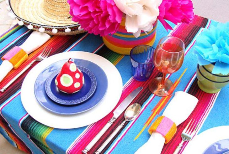 A fiesta table decorated with flowers and serape