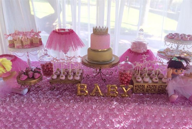 A grand baby shower cake for a girl with pink tutus and dolls