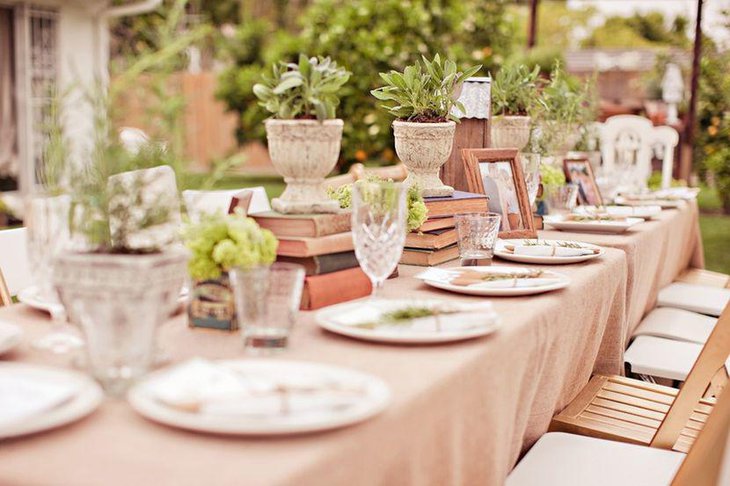 A natural themed outdoor bridal shower table styled with plants and books