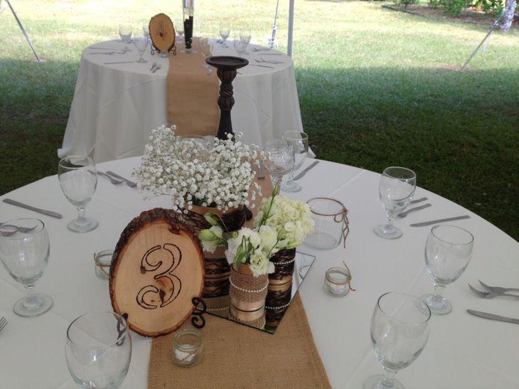 A stylish and wam looking country wedding table decorated with burlap accents