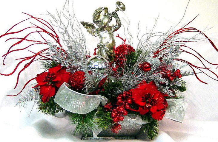 Alluring Christmas Red and Silver Floral Arrangement Centerpiece With A Cherub Blowing A Trumpet