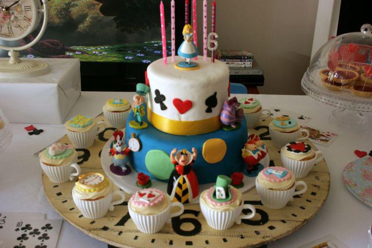 Amazing Alice in Wonderland tea party table with baked tea cups and Wonderland fondant topper